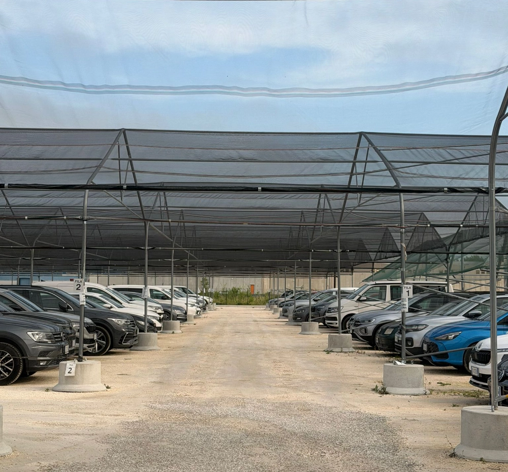 Parvis de concessionnaire couvert par une structure Euromet — rangées de véhicules protégés