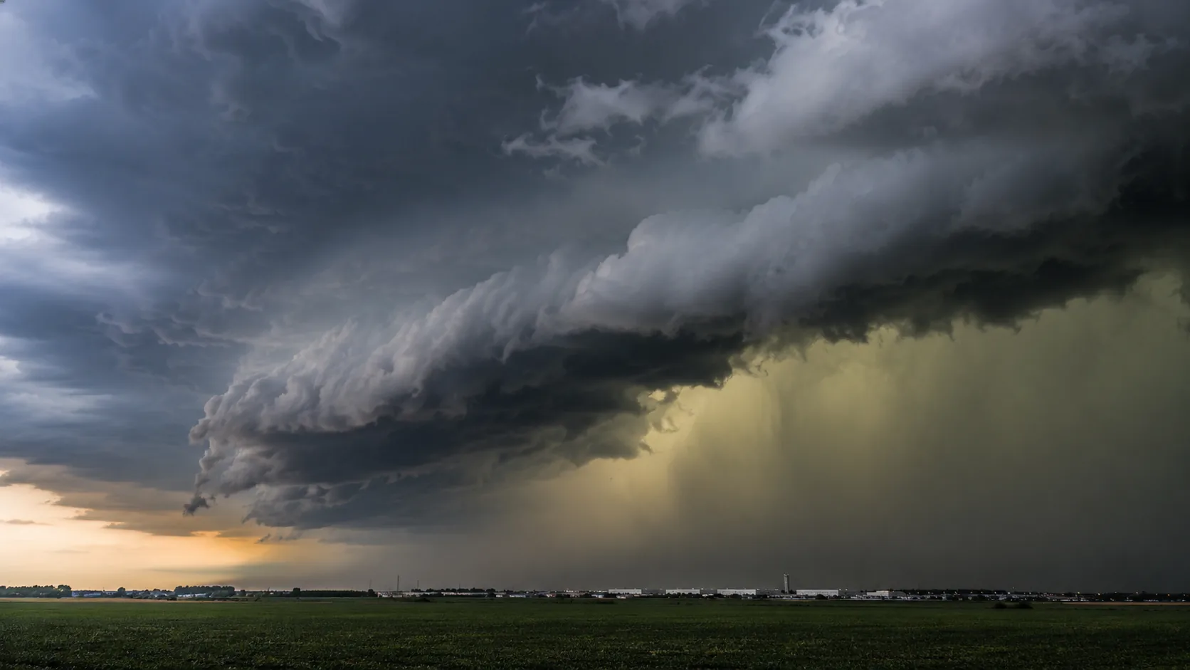 Imposante shelf cloud orageuse avec downburst et averse de grêle sur une zone industrielle